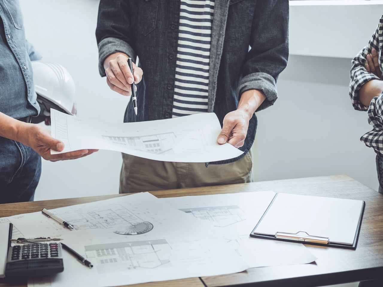 AdobeStock_271469637 Construction and structure concept of Engineer or architect meeting for project working with partner and engineering tools on model building and blueprint in working site, contract for both companies.
